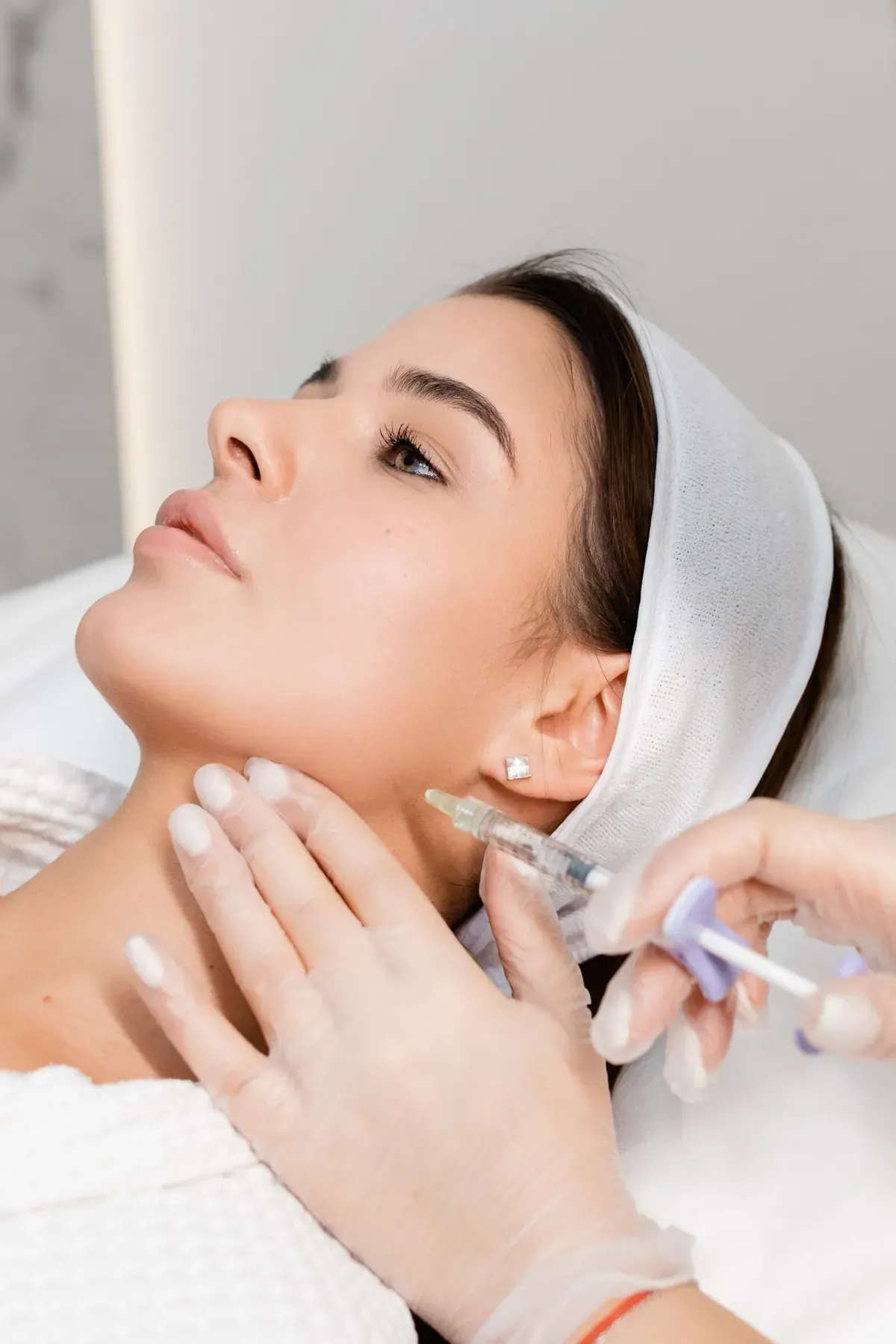 Toxina Botulínica em Joinville Paciente com touca em atendimento com aplicação injetável facial na Clínica Dra. Simoni Bett, Joinville